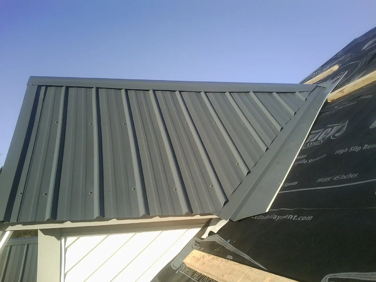 Gray metal roof panels going on over a garage gable in Laporte