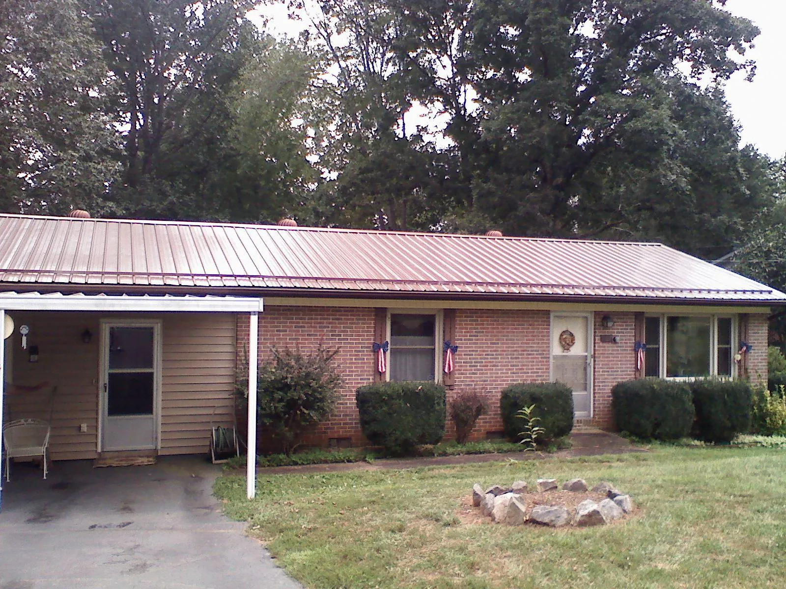 Bronze metal roof and carport on a brick ranch home — Roof Repair work by our crew in Laporte